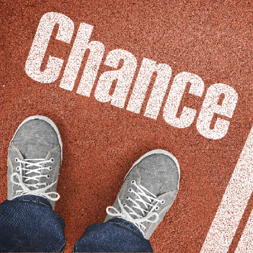 das Wort "Chance" geschrieben auf rotem Asphalt