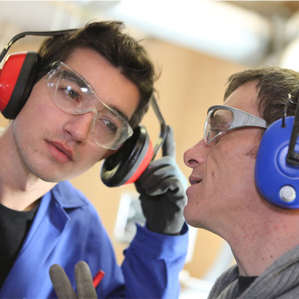 Zwei Männer mit Ohrschützern bei der Arbeit