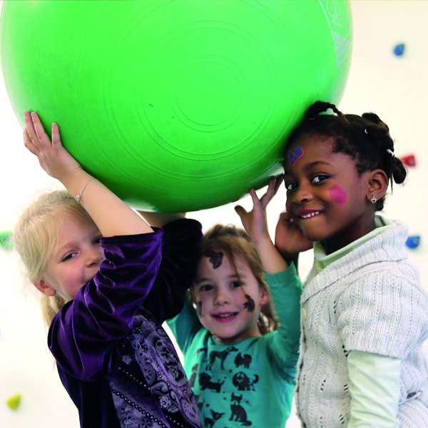 eine Gruppe von Kindern beim Spielen mit einem Gymnastikball